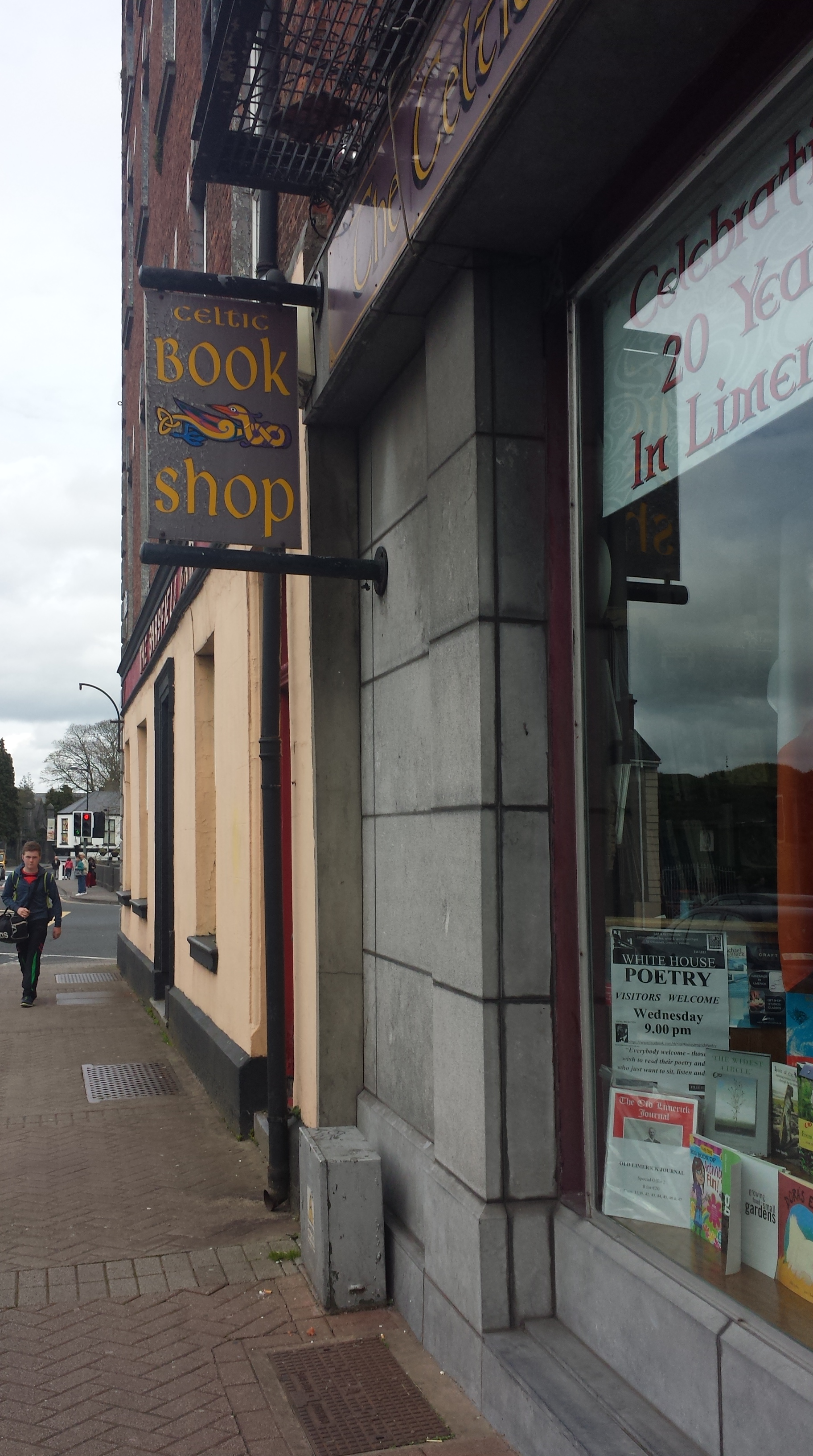 Photo of a Celtic Book Shop sign. The letters are in the Celtic swirl font, the color yellow on a grey back drop.