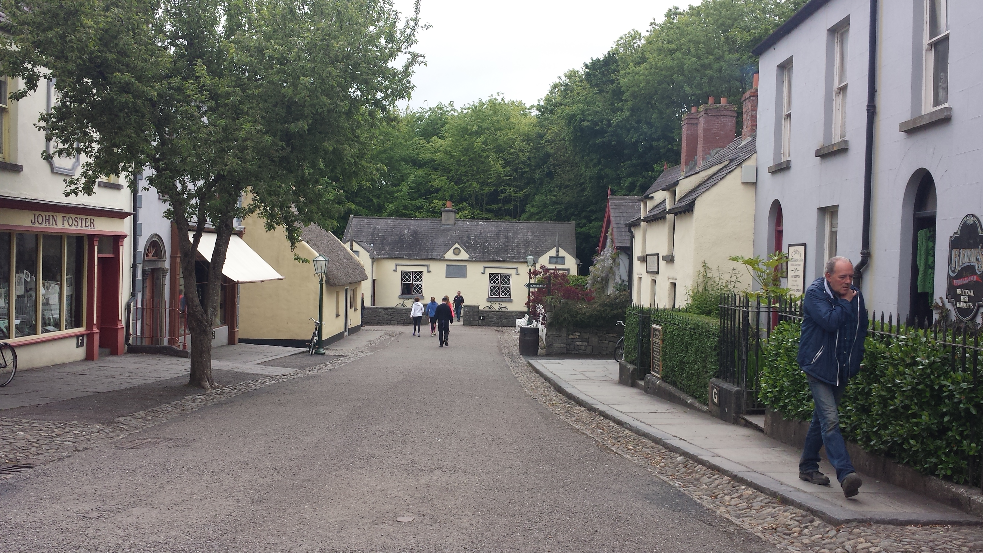 picture of a small town. There are colorful, traditional irish buildings on either side of the road.